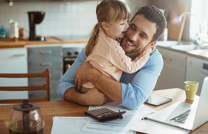 Father and daughter hugging by the desk